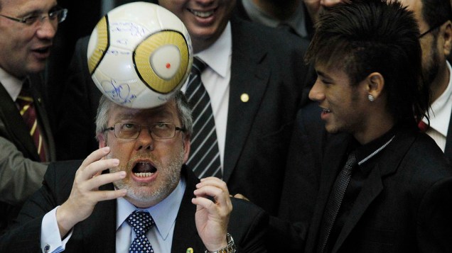 Marco Maia, presidente da Câmara dos Deputados arrisca embaixadas ao lado do jogador Neymar durante sessão em homenagem ao centenário do Santos em Brasília