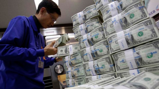 Funcionário de banco coreano conta notas de dólar em Seul, Coréia do Sul