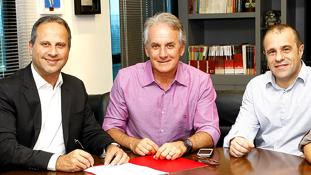 O apresentador Otávio Mesquita (centro) assina contrato com o SBT, ao lado do VP do canal, José Roberto Maciel, e Fernando Pelegio, diretor de planejamento artístico da emissora