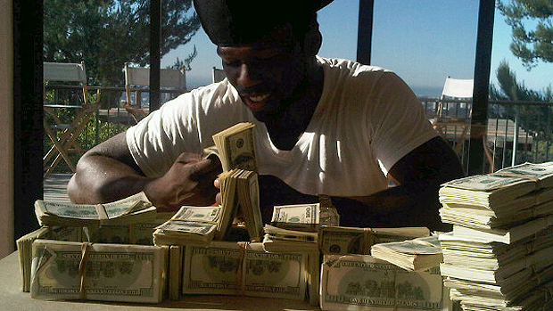 O rapper 50 Cent brincando com dinheiro