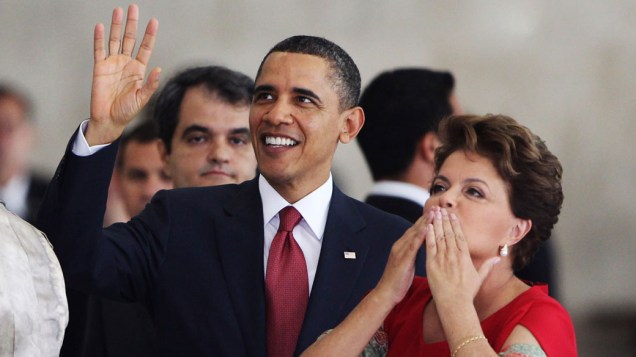 Presidente Barack Obama acena para o público, acompanhado da presidente Dilma, em Brasília