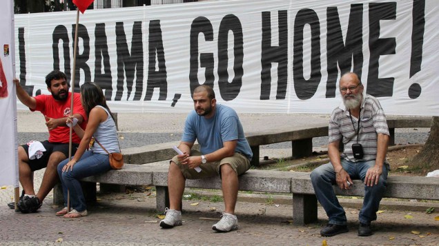 Faixa de manifestantes pedem que o presidente Barack Obama retorne para os Estados Unidos