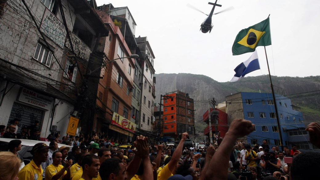 Militares e moradores acompanham a cerimônia de hasteamento das bandeiras na favela da Rocinha, no Rio de Janeiro