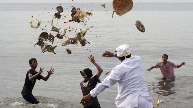 Hindus jogam oferendas no mar durante o festival “Melasti”, em Sanur, Indonésia
