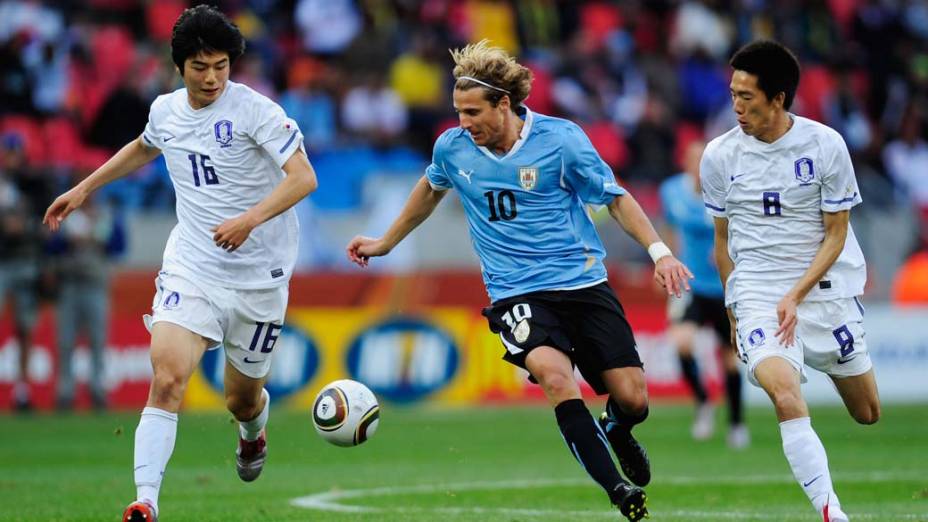 Atacante uruguaio Diego Forlan tenta sair da marcação da Coreia do Sul