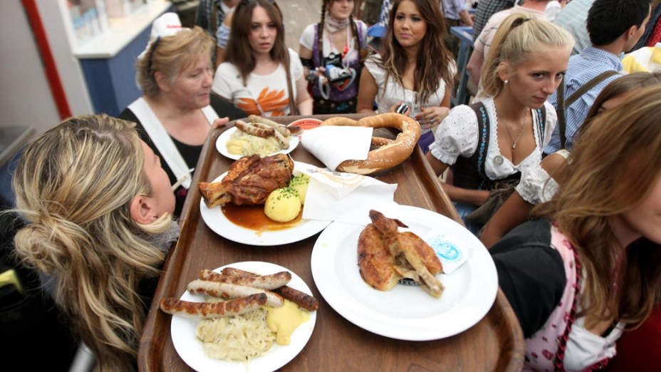 Garçonete do Oktoberfest carrega pratos bávaros