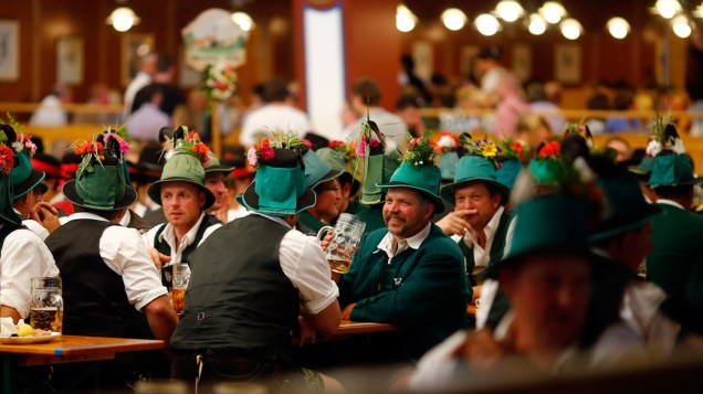 Pessoas com roupas tradicionais da Baviera fazem uma pausa após o desfile da Oktoberfest em Munique