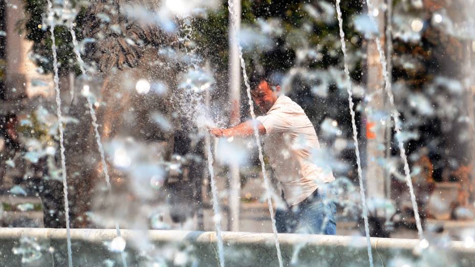 Na Macedôna, com temperaturas acima dos 40ºC, habitantes de Skopje se refrescam em fonte