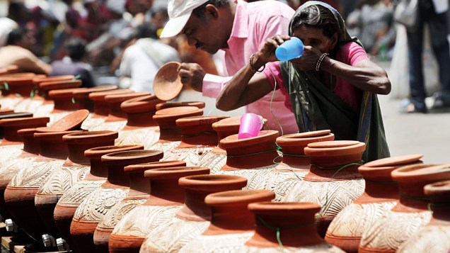 Em meio à forte onda de calor, mulher bebe água em Nova Délhi