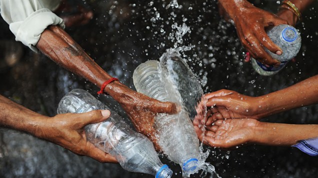 Agricultores indianos se refrescam em meio a forte onda de calor em Nova Délhi