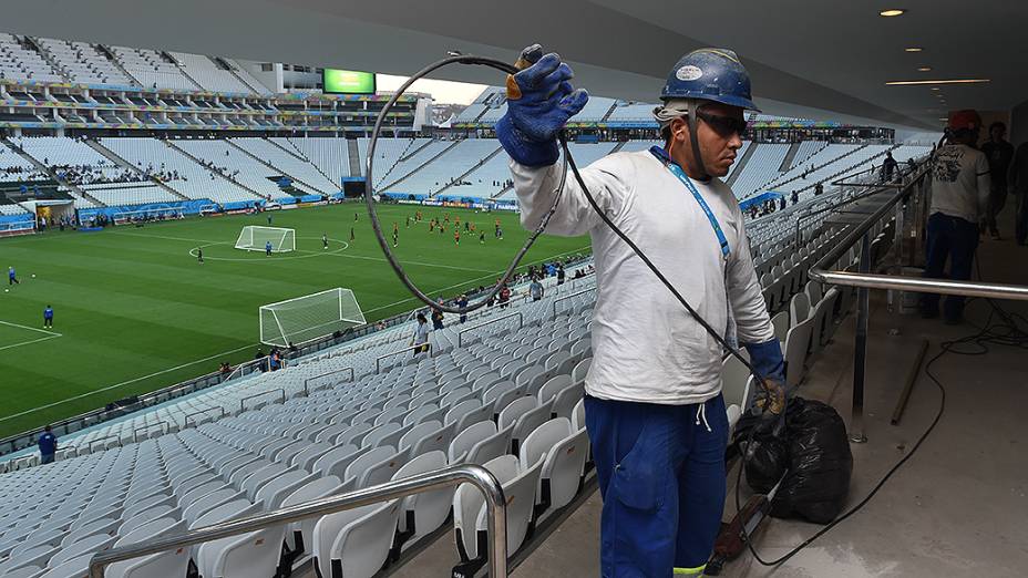 Funcionários fazem últimos ajustes no Itaquerão enquanto a seleção brasileira treina, em São Paulo