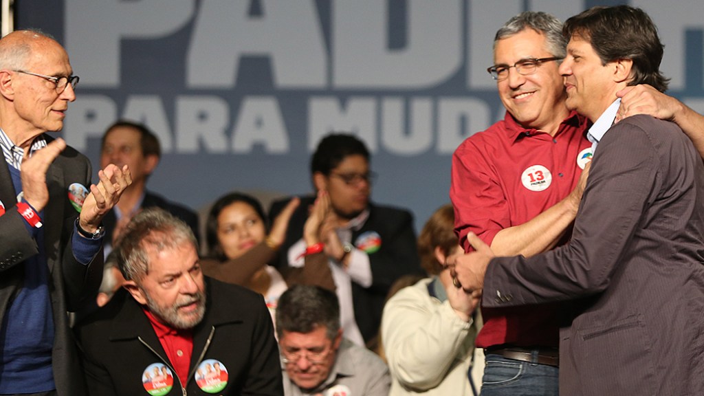 REABILITAÇÃO – Sob olhares de Lula e Suplicy, Alexandre Padilha e Fernando Haddad se abraçam na plenária do PT nacional em São Paulo – 05/09/2014