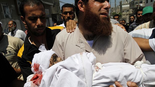 Palestinos da faixa de Gaza carregam criança vítima de bombardeio israelense