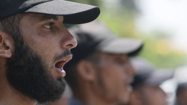 Policial do governo do Hamas participa de passeata nas ruas, no mesmo dia das execuções