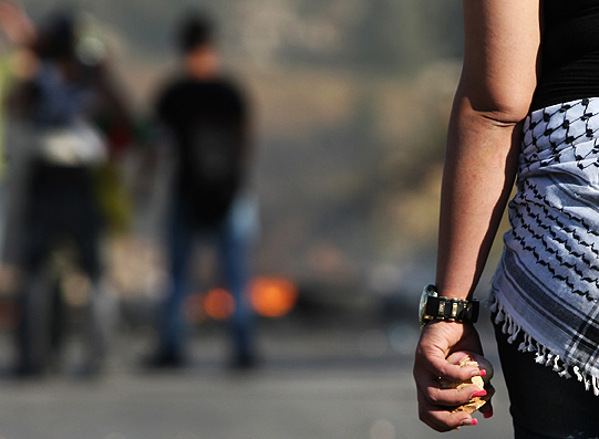Manifestantes palestinos jogam pedras contra soldados israelenses durante protesto na aldeia de Kafr Qaddum, na Cisjordânia
