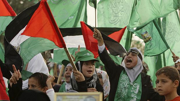 Palestinos comemoram a libertação de presos sacudindo bandeiras do Hamas