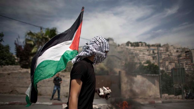 Palestinos bloqueiam rua durante protesto no bairro de Silwan, Israel