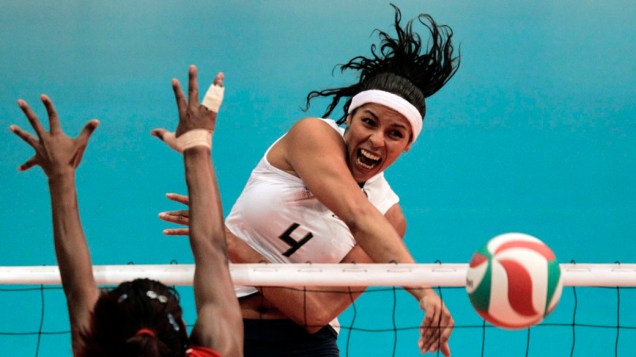 A brasileira Paula Pequeno faz um corte enquanto jogadora da República Dominicana, Cindy Rondon, tenta bloqueio durante partida da semifinal de vôlei, no quinto dia dos Jogos Pan-Americanos em Guadalajara, México, em 19/10/2011