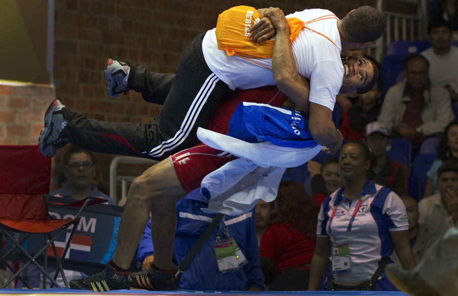 Brea Anyelo Mota da República Dominicana comemora, com seu técnico, vitória sobre o mexicano Ulises Barragan em partida de luta livre, no sexto dia dos Jogos Pan-Americanos em Guadalajara, México, em 20/10/2011