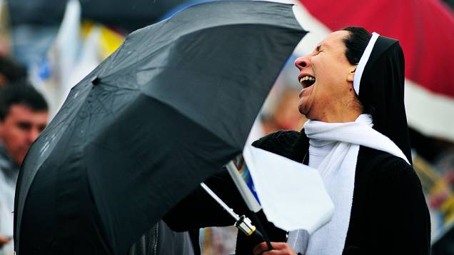 Fiéis aguardam a chegada do papa Francisco debaixo de chuva em Aparecida do Norte