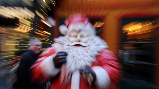 As pessoas passam por uma estátua de Papai Noel em um mercado de Natal na cidade alemã de Dusseldorf, Alemanha