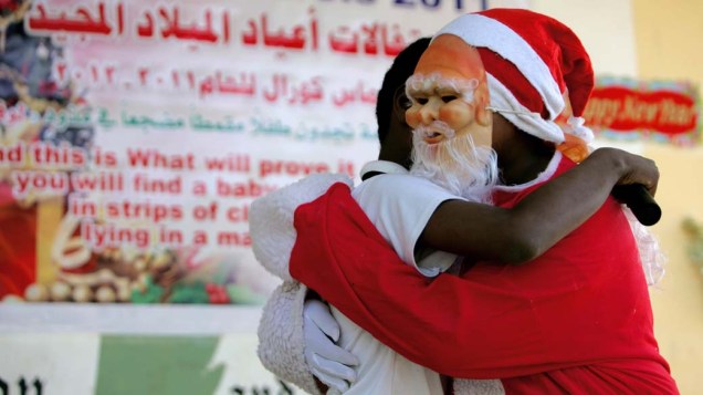 Papai Noel sudanês abraça um aluno durante as celebrações de Natal em uma escola em Sudão