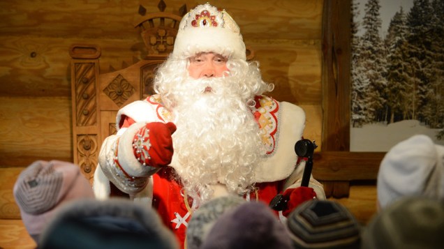 Na Rússia, homem vestido de Papai Noel conversa com crianças em mercado de natal de Moscou
