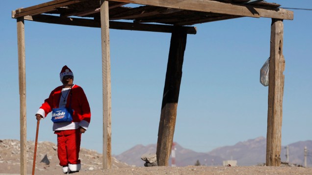 Homem aguarda ônibus vestido de Papai Noel em Cidade Juarez, no México