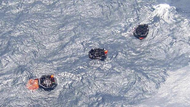 Botes salva-vidas que transportam sobreviventes flutuam em águas agitadas em Papua Nova Guiné