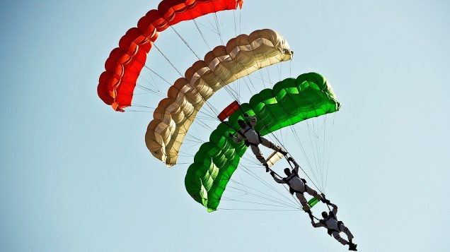Paraquedistas da Força Aérea Indiana demonstram habilidades durante um salto, antes de pousar na base aérea de Hindon, perto de Nova Délhi