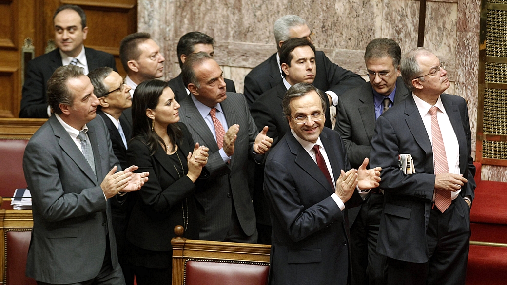 Premiê grego, Antonis Samaras (de gravata vinho), comemora aprovação do Orçamento para 2013 junto com parlamentares