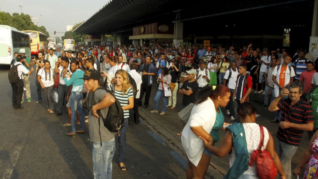 Passageiros que aguardavam ônibus na Avenida Presidente Vargas, ao lado da Central do Brasil, fecham a pista lateral de descida sentido Zona Norte