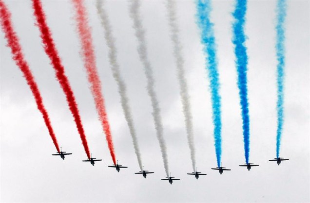 Aviões da "Patrulha de França" passam sobre o Arco do Triunfo pintando com fumaça a bandeira francesa, durante a celebração do 223º aniversário da queda da Bastilha.