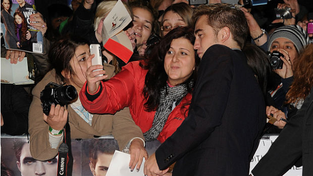 O ator Robert Pattinson tira foto com fãs durante première de Amanhecer - Parte 2 em Londres