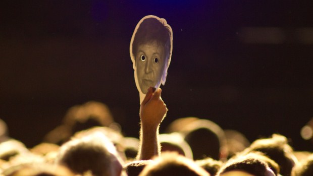 O público levou máscaras com a rosto do ex-Beatle para o show