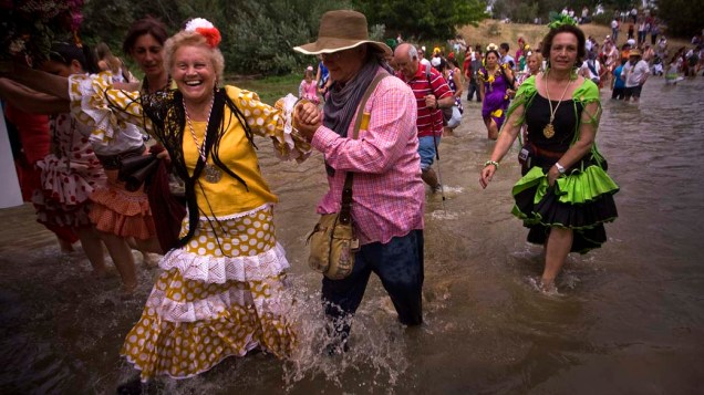 Peregrinos atravessam o rio Quema à caminho do santuário de El Rocio, na cidade de Villamanrique, Espanha