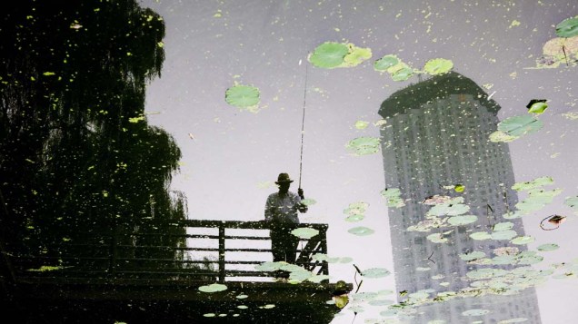 Homem pescando em um canal em Pequim, China