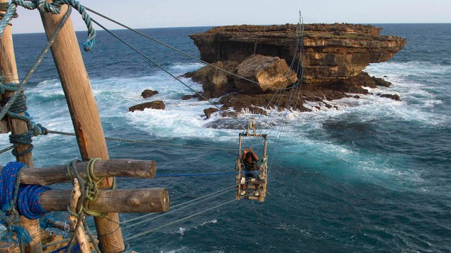 Pescador indonésio atravessa o mar na praia de Timang, Indonésia em um teleférico feito por ele mesmo Pescador indonésio atravessa o mar na praia de Timang, Indonésia em um teleférico feito por ele mesmo