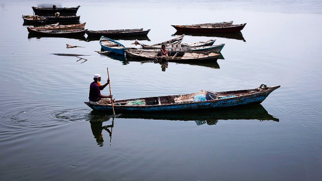 Pescador rema seu barco em um lago aos arredores de Karachi, no Paquistão