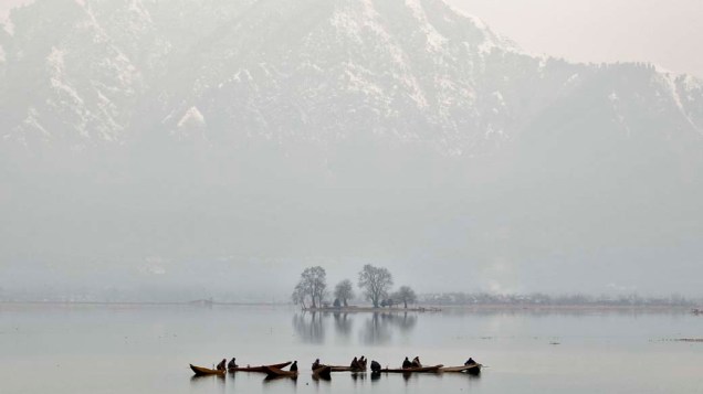 Pescadores em lago na cidade de Srinagar, Índia
