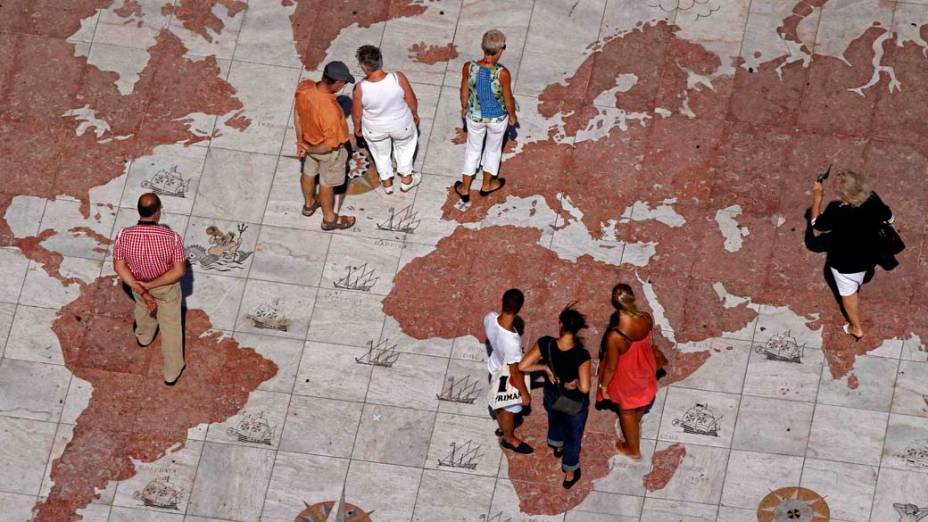 Pessoas em mapa-múndi gravado em mármore em Lisboa, Portugal