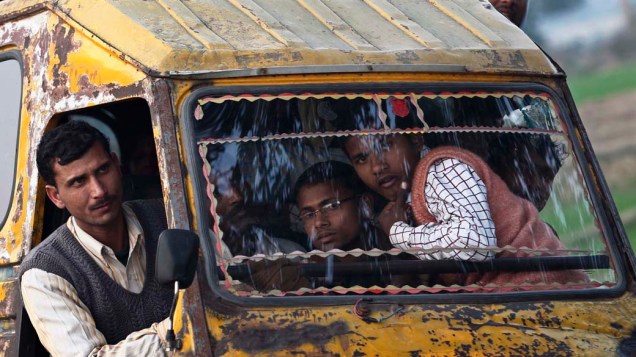 Pessoas viajam em riquexá motorizado, na Índia