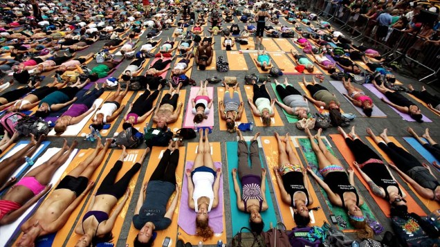 Em Nova York, centenas de pessoas praticam yoga na Times Square durante evento que marca o solstício de verão