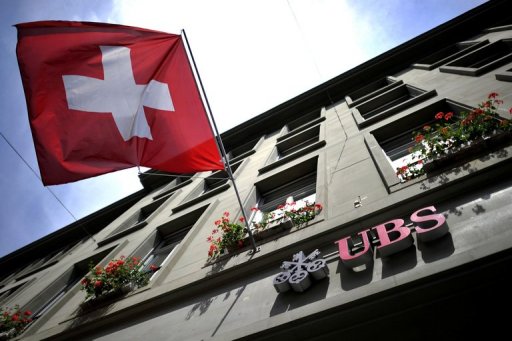 Bandeira suíça diante de agência do banco UBS em Berna