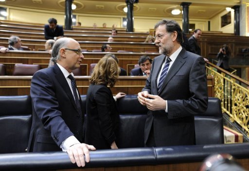 O presidente do governo, Mariano Rajoy (d), conversa com o ministro da Fazenda, Cristóbal Montoro, no Congresso