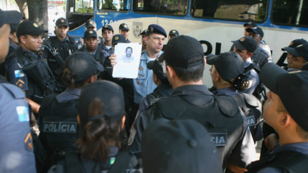 Reunidos para a operação na favela da Rocinha, PMs exibem a foto do suspeito de matar um cabo da Polícia Militar na favela