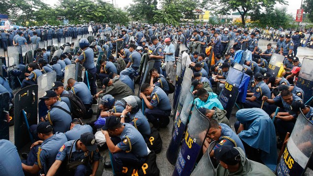 Centenas de policiais descansam durante bloqueio ao Congresso para impedir que manifestantes protestem contra o presidente Benigno Aquino III, que fará um pronunciamento para o país nesta segunda-feira