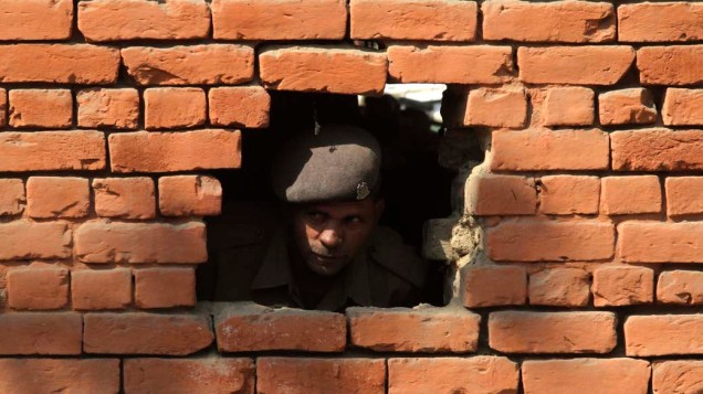Soldado indiano vigia posto demolido em Srinagar. De acordo com jornais locais, os soldados destruíram postos de segurança e libertaram manifestantes presos como medida para aliviar as tensões na região