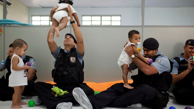 Policiais brincam com crianças em visita a uma creche da Cidade de Deus: ações sociais para reaproximar PM e moradores
