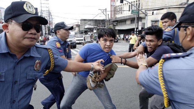 Policiais tentam controlar estudantes durante protesto contra a visita de Hillary Clinton em Manila, nas Filipinas